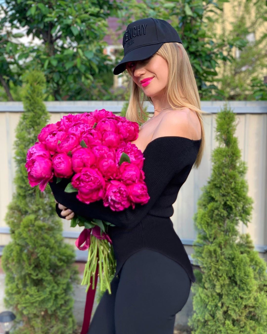 Яскрава квітка: Леся Нікітюк в total black прикрила пікантне декольте букетом півоній