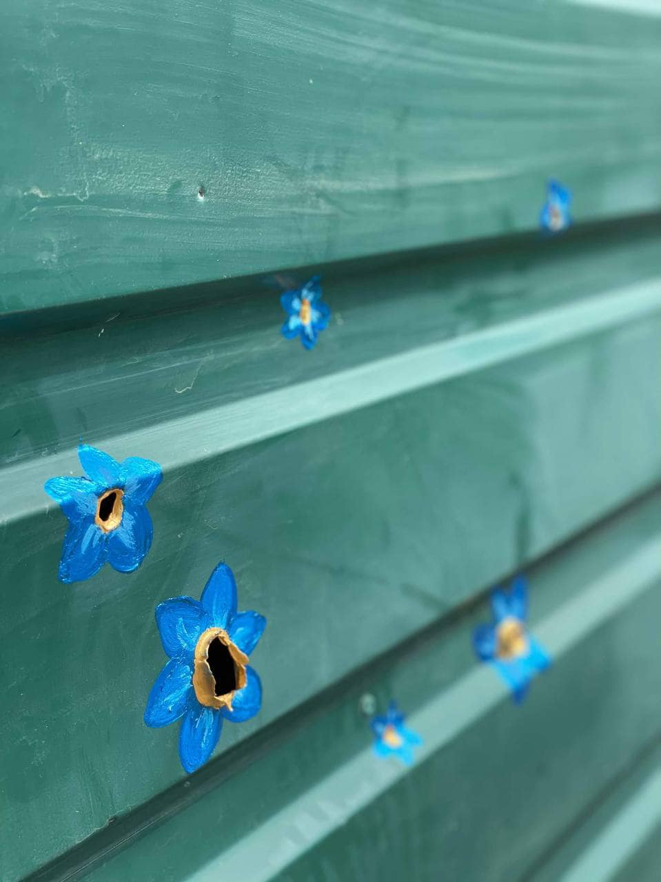 У Бучі художниця &quot;перетворила&quot; отвори від куль у квіти (фото)