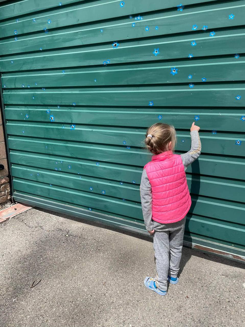 У Бучі художниця &quot;перетворила&quot; отвори від куль у квіти (фото)