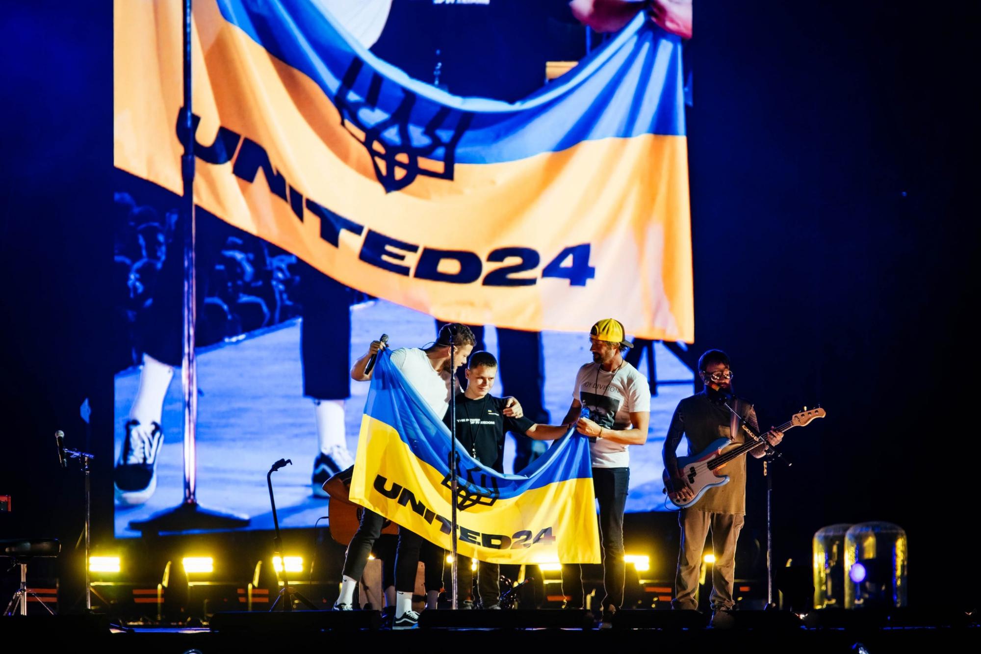 "Остаемся с Украиной". Солист Imagine Dragons во время концерта поцеловал сине-желтый флаг (видео)