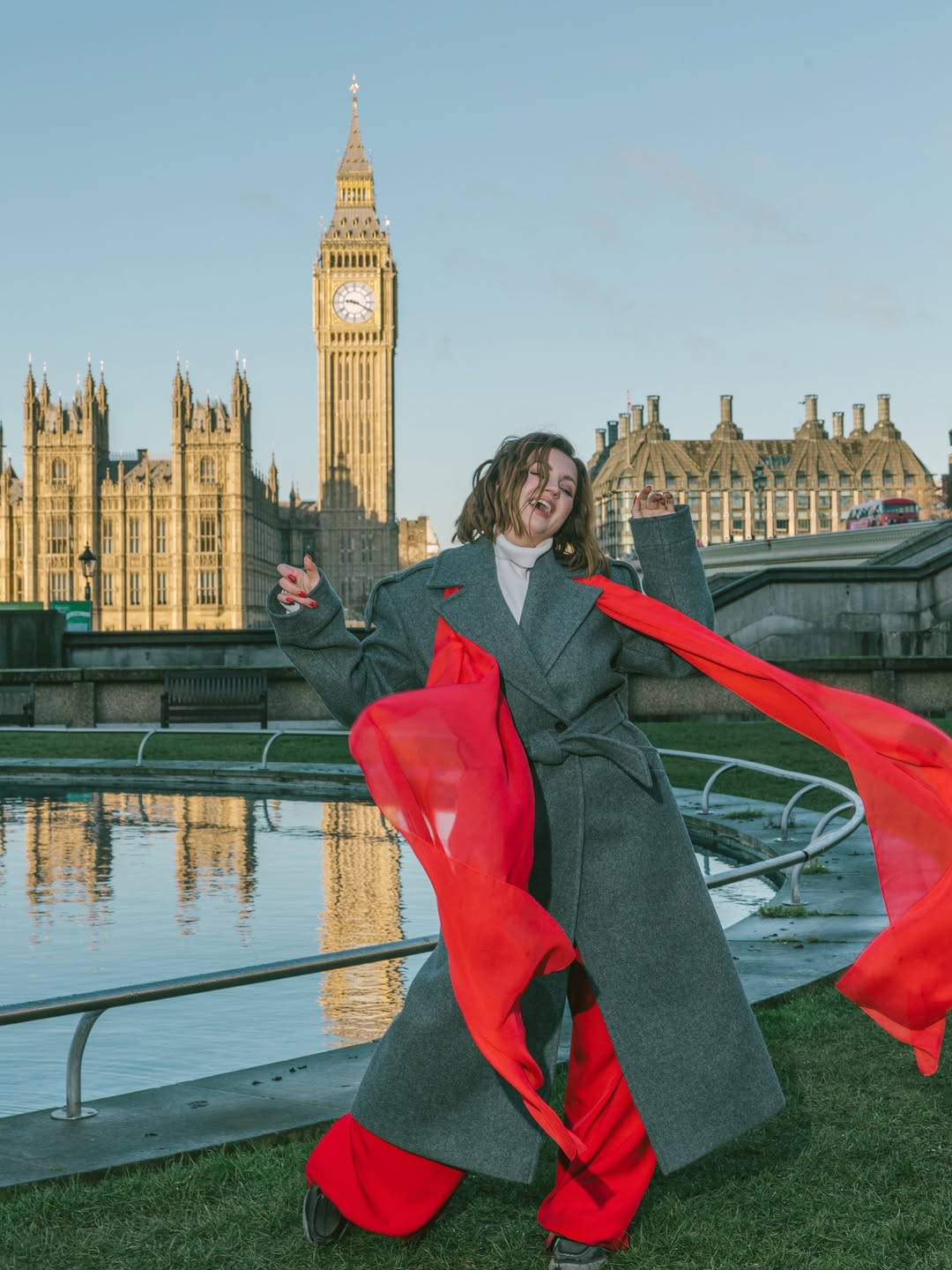 Серое пальто и красный акцент: стильный лондонский образ Оли Цыбульской