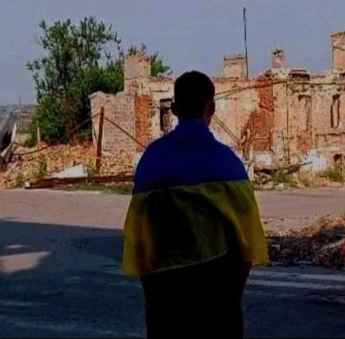 В Мариуполе парень сфотографировался возле разбомбленного дома с флагом Украины