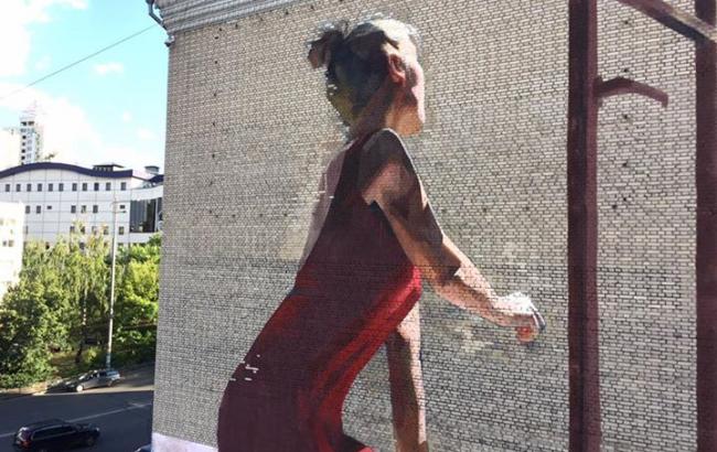 У Києві з'явився метафоричний мурал з дівчиною біля підвіконня