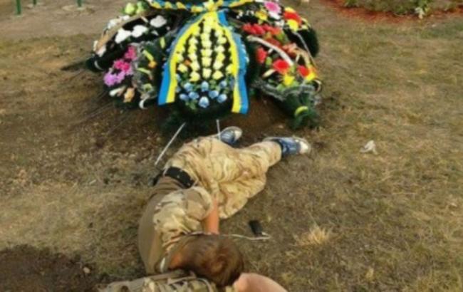 Мороз по коже: стала известна история фото, на которой боец АТО лежит возле могилы собрата