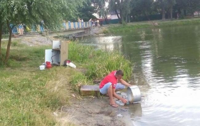В Киеве продавец сладкой ваты моет оборудование в озере